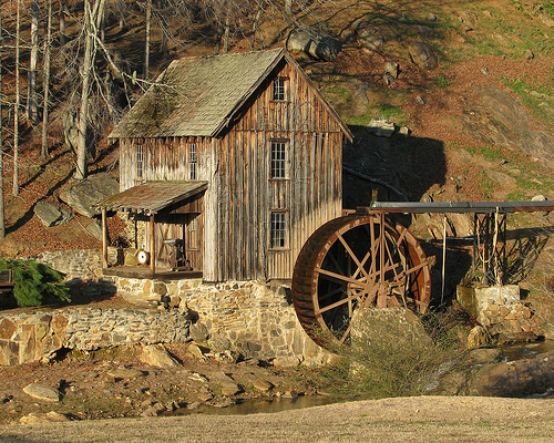 A historic gristmill with a wooden water wheel